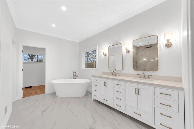 a bathroom with a sink double vanity mirror and bathtub
