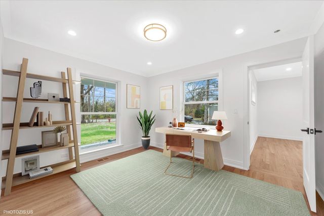 a view of a workspace with furniture and a window