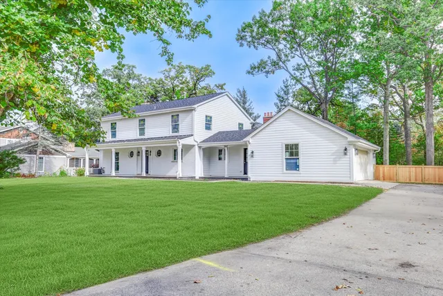 a view of a house with a big yard with large trees