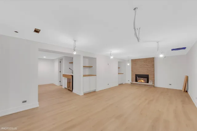 a view of a livingroom with a fireplace a ceiling fan and window
