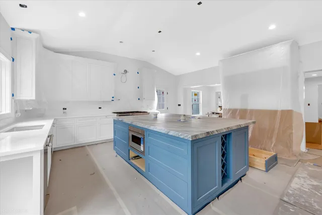 a kitchen with granite countertop a sink and a stove top oven