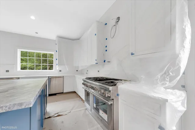 a kitchen with granite countertop a stove sink and cabinets