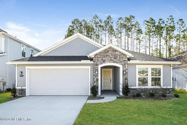 a front view of a house with a garden and plants