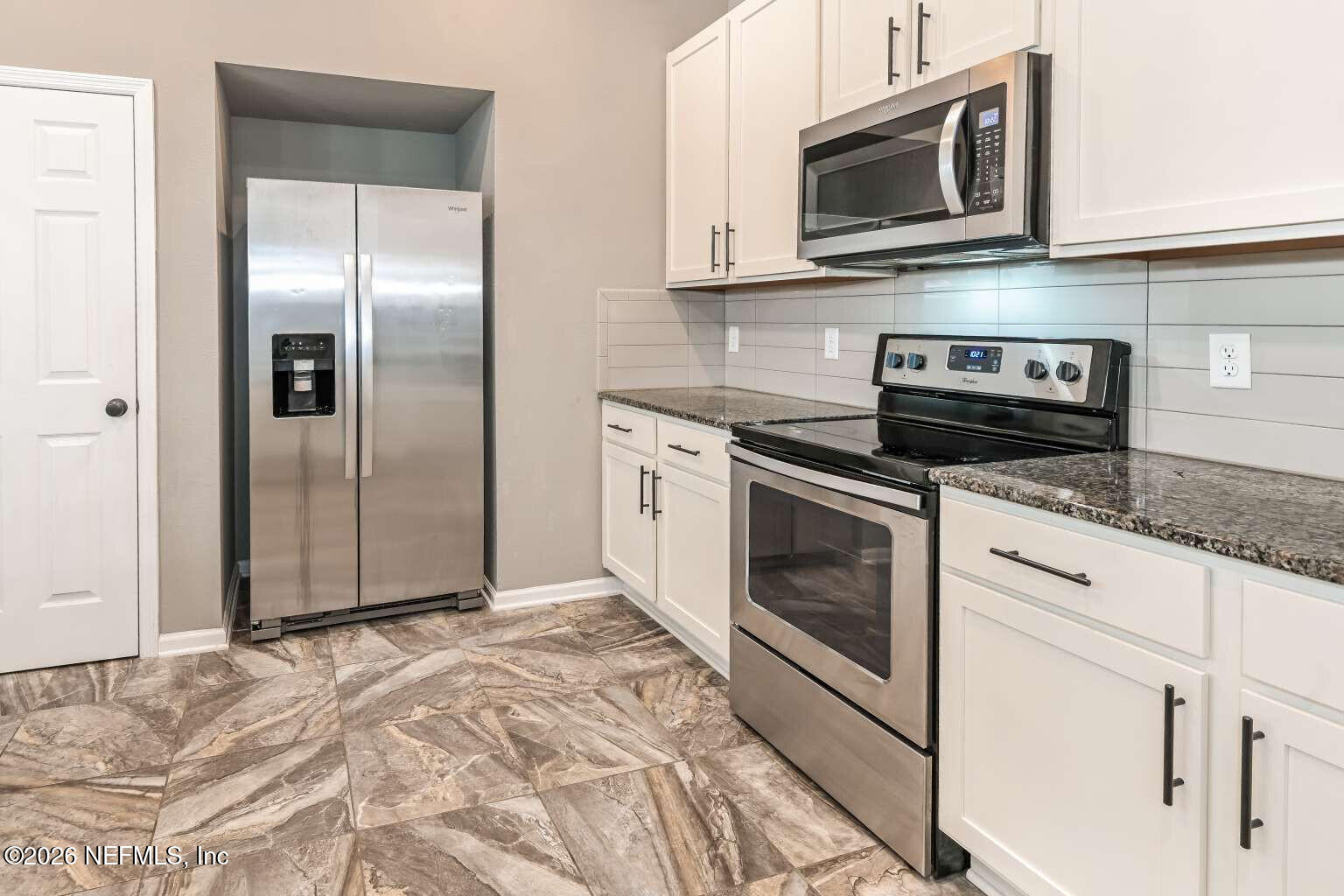 97572 Albatross Drive Yulee, FL 32097 - Photo 13 of 20 a kitchen with granite countertop white cabinets stainless steel appliances and a sink