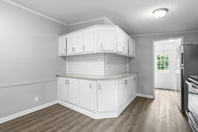 a kitchen with granite countertop white cabinets and white appliances