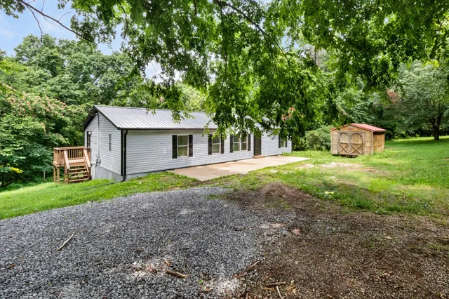 a view of a house with backyard and trees
