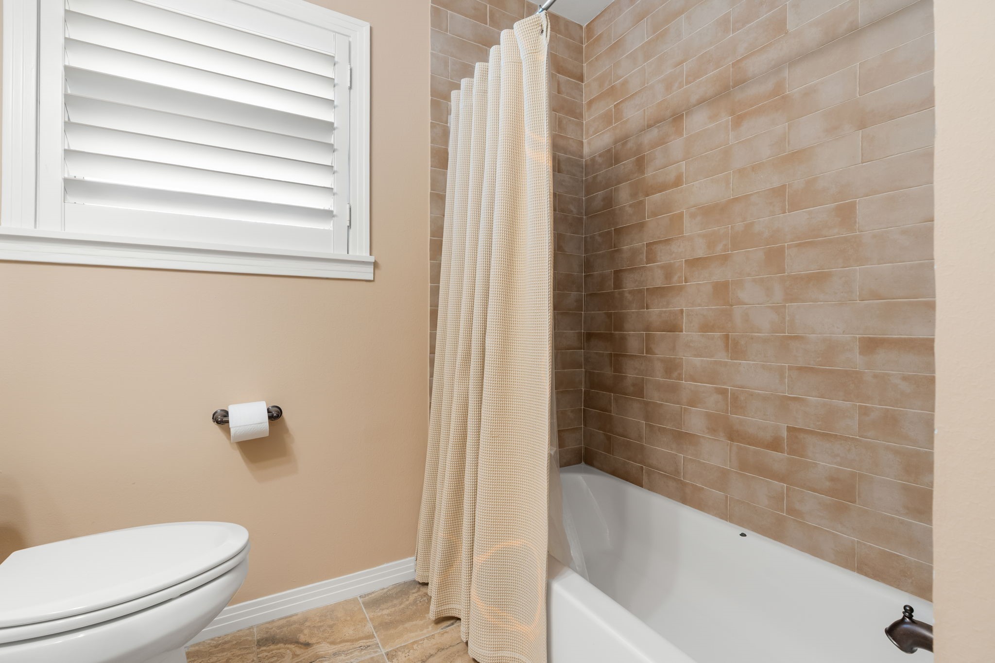 1115 Woodhill Road Houston, TX 77008 - Photo 16 of 29 Second bath features a tub shower combo with new tile to the ceiling.