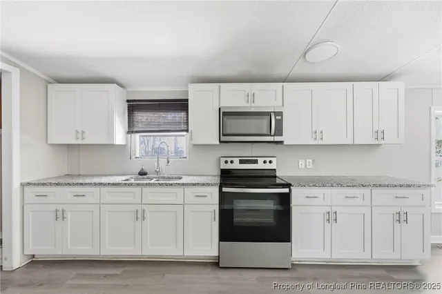 a kitchen with stainless steel appliances granite countertop a sink and dishwasher a stove top oven with wooden floor