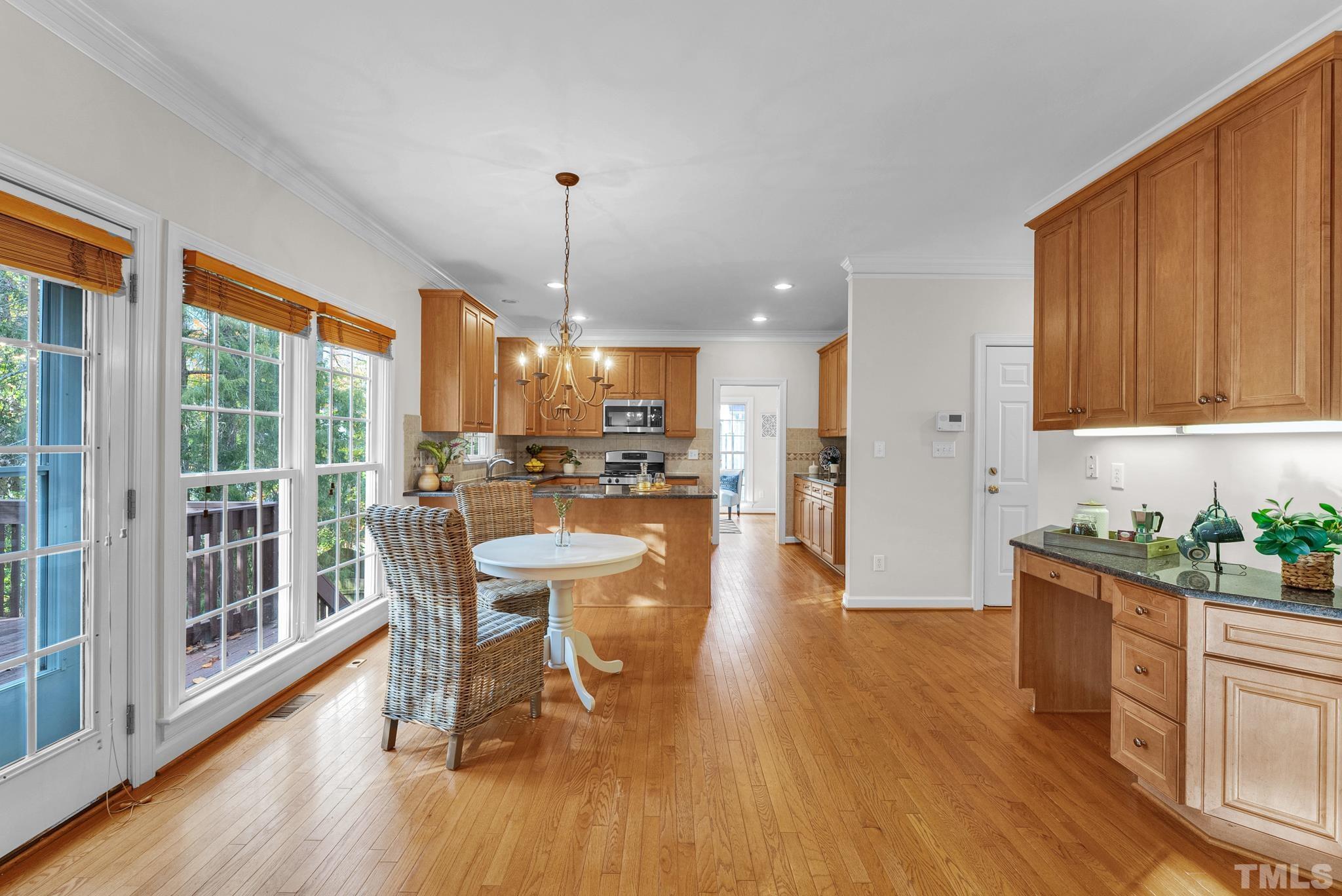 8409 Aptos Court Raleigh, NC 27613 - Photo 17 of 46 a kitchen with a table chairs refrigerator and wooden floor