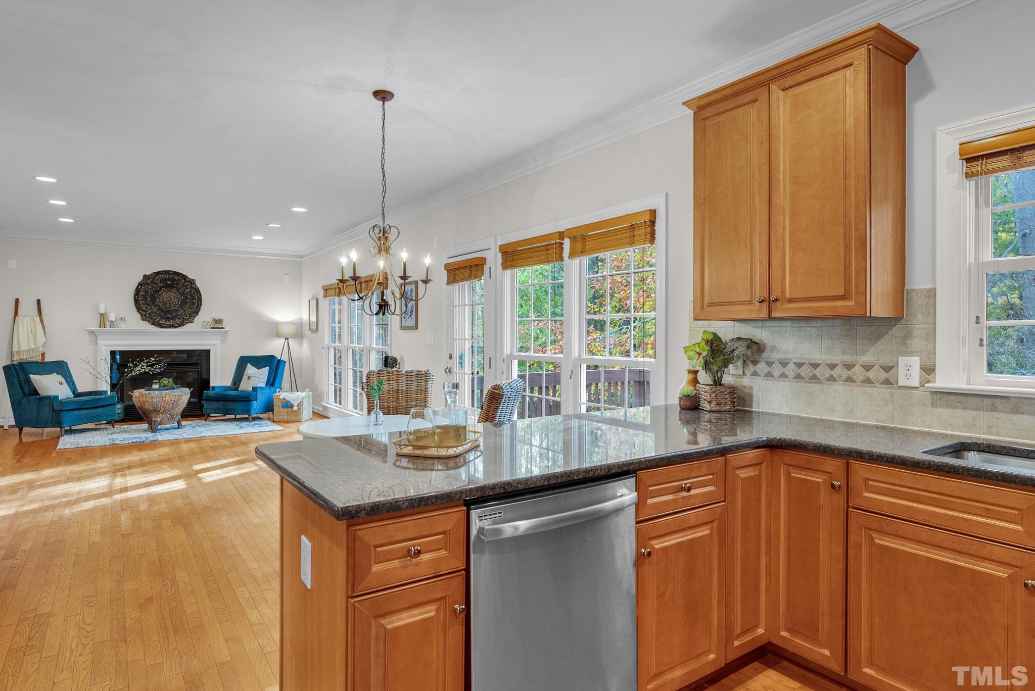 8409 Aptos Court Raleigh, NC 27613 - Photo 24 of 46 a kitchen with kitchen island granite countertop a sink cabinets and window
