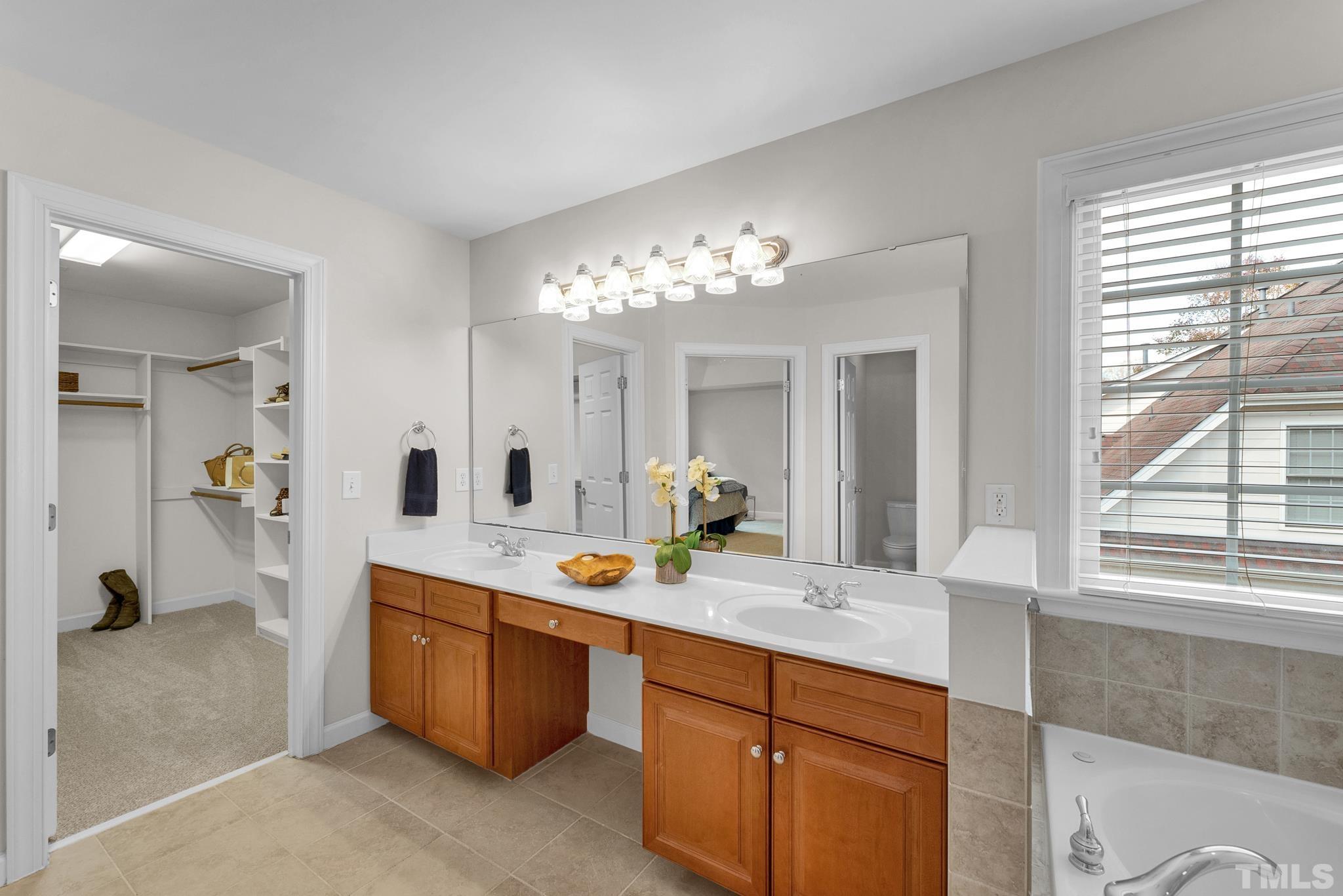 8409 Aptos Court Raleigh, NC 27613 - Photo 33 of 46 a bathroom with a tub sink and mirror