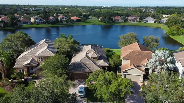 an aerial view of a residential houses with outdoor space and lake view