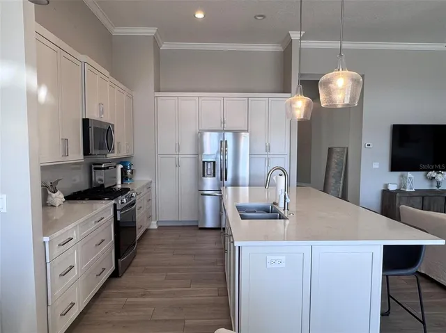 a kitchen with kitchen island granite countertop a sink appliances and cabinets