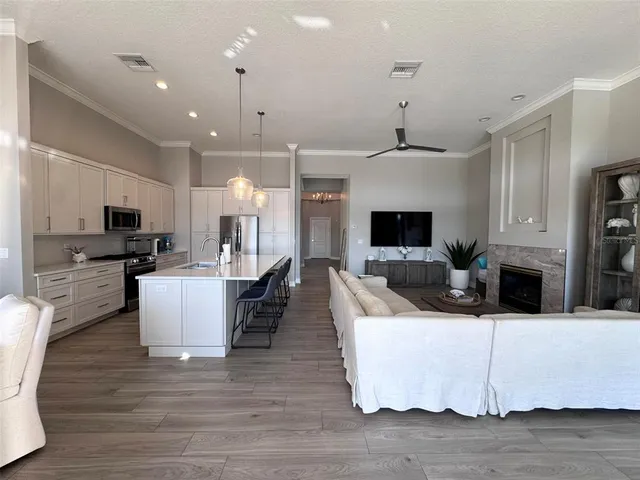 a large kitchen with stainless steel appliances granite countertop a sink a stove and a wooden floor