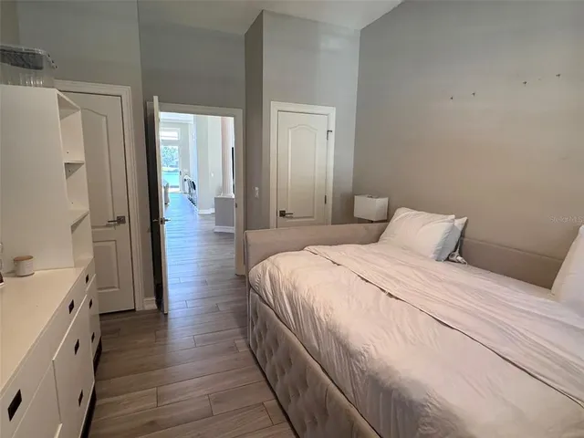 a spacious bedroom with a bed and a dresser