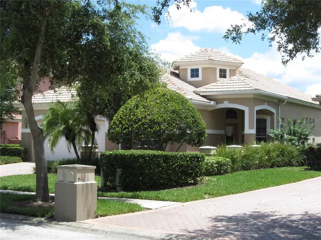 a front view of a house with a yard and trees