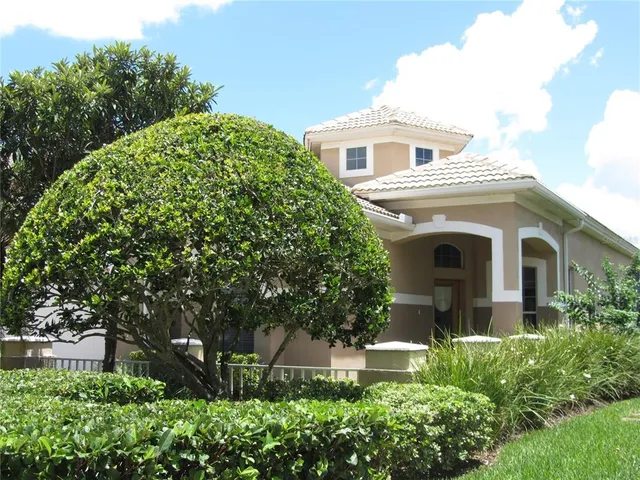 a front view of a house with plants and trees