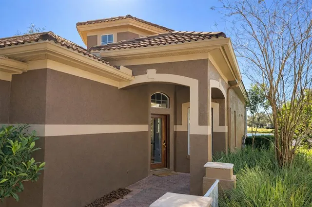 a view of an empty room with wooden floor and chandelier