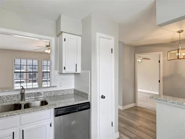 a kitchen with granite countertop a sink and a refrigerator