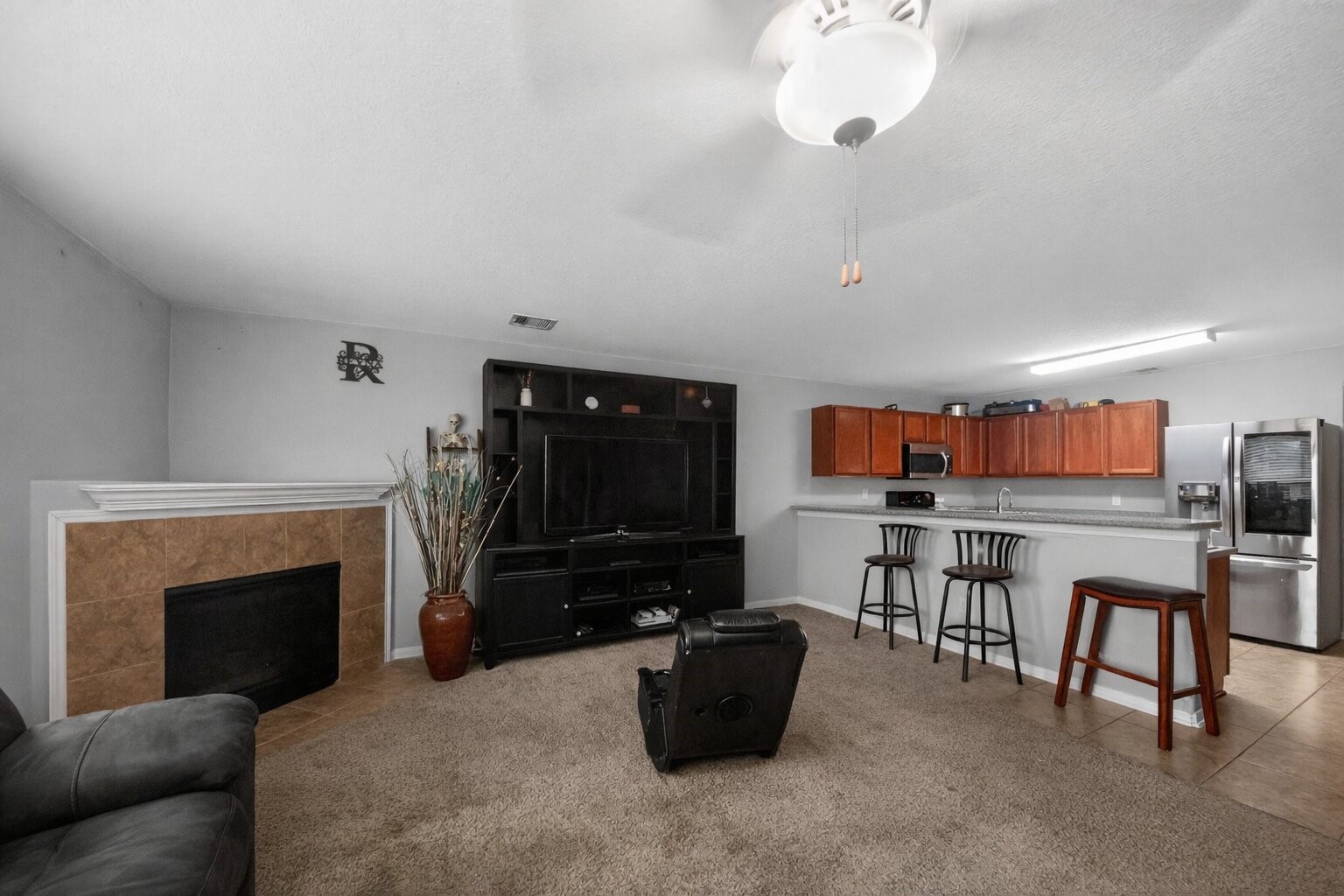 7902 Sesame Street Baytown, TX 77521 - Photo 5 of 24 a living room with furniture a flat screen tv and a fireplace
