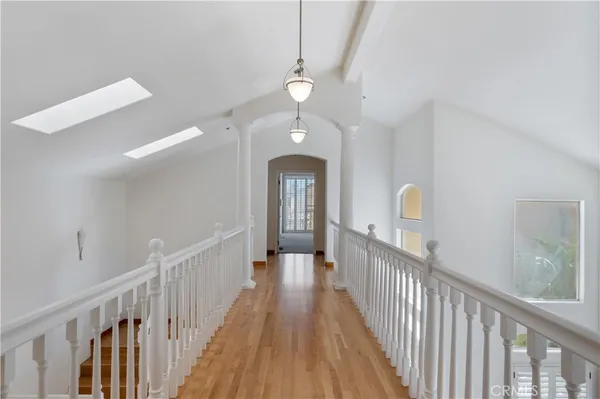 a view of a hallway with wooden floor and staircase