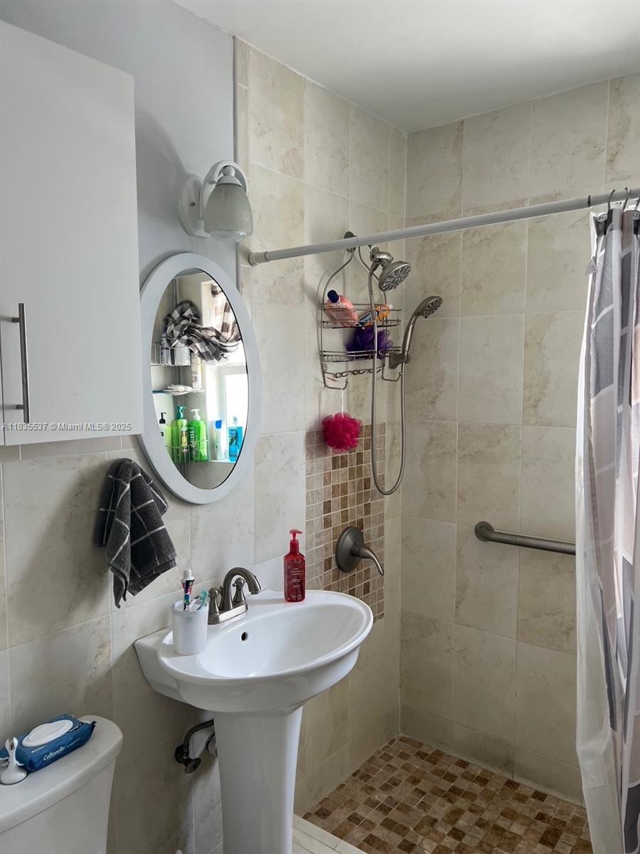 7595 Southwest 28th Street Miami, FL 33155 - Photo 4 of 8 a bathroom with a sink a toilet and shower