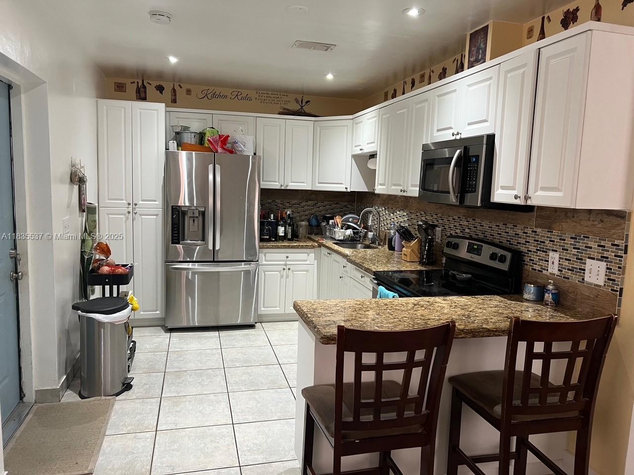 7595 Southwest 28th Street Miami, FL 33155 - Photo 6 of 8 a kitchen with stainless steel appliances granite countertop a stove a sink and a refrigerator