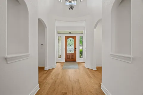 a view of a hallway view with wooden floor and a window