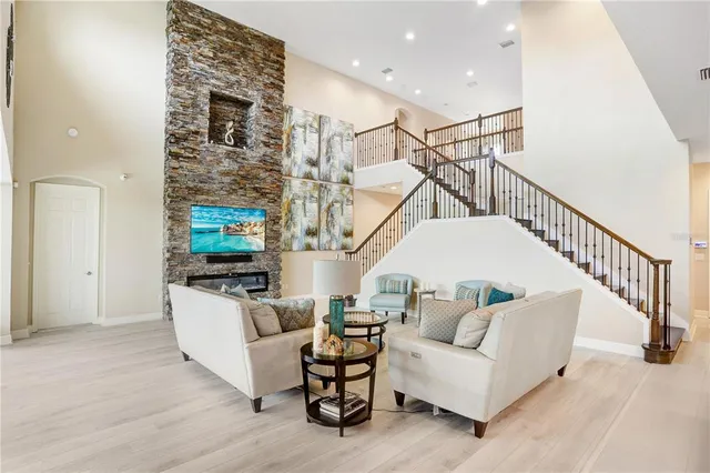 a kitchen with kitchen island granite countertop a sink a stove a refrigerator cabinets and chairs