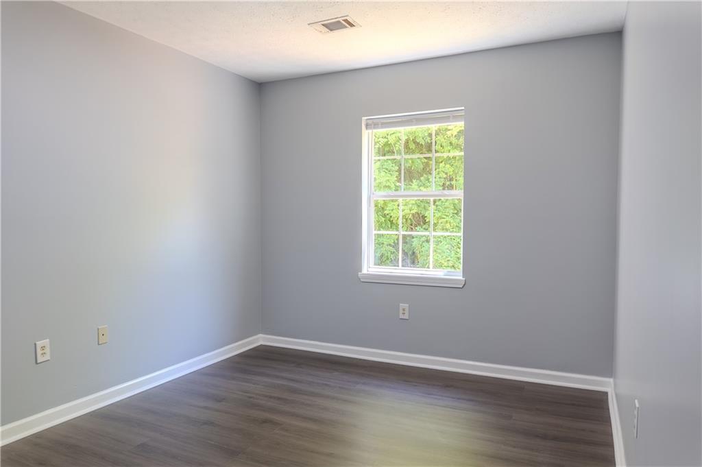 53 Washington Drive Forsyth, GA 31029 - Photo 9 of 19 an empty room with wooden floor and a window