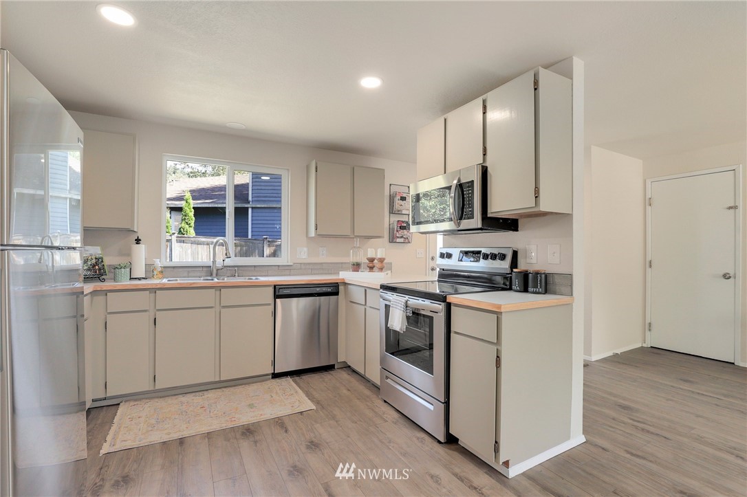 1017 234th Place Southwest Bothell, WA 98021 - Photo 12 of 28 a kitchen with stainless steel appliances granite countertop a sink a stove a refrigerator and cabinets