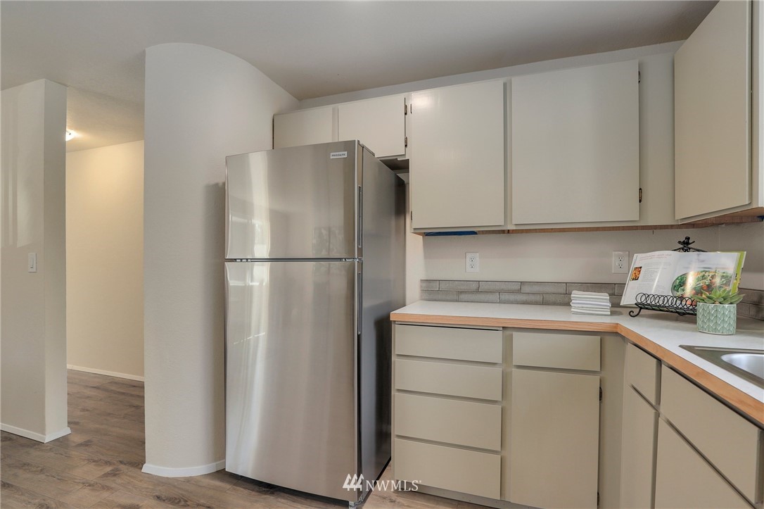 1017 234th Place Southwest Bothell, WA 98021 - Photo 14 of 28 a kitchen with a refrigerator sink and cabinets