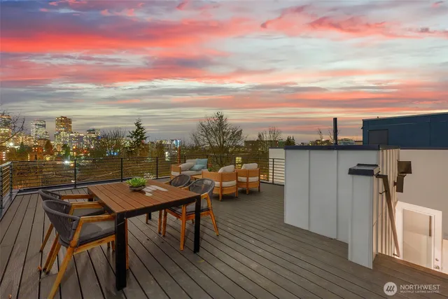a roof deck with wooden floor and seating space