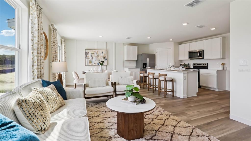 4694 Kona Circle Spring Hill, FL 34608 - Photo 12 of 29 a living room with furniture and a dining table with kitchen view