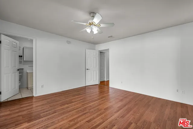 a view of an empty room with wooden floor