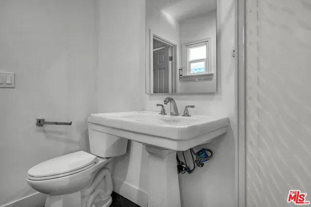 a bathroom with a sink a toilet and a mirror