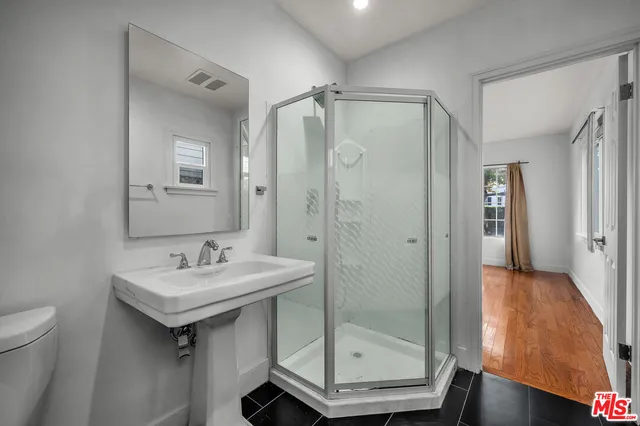 a bathroom with a shower a sink and a mirror