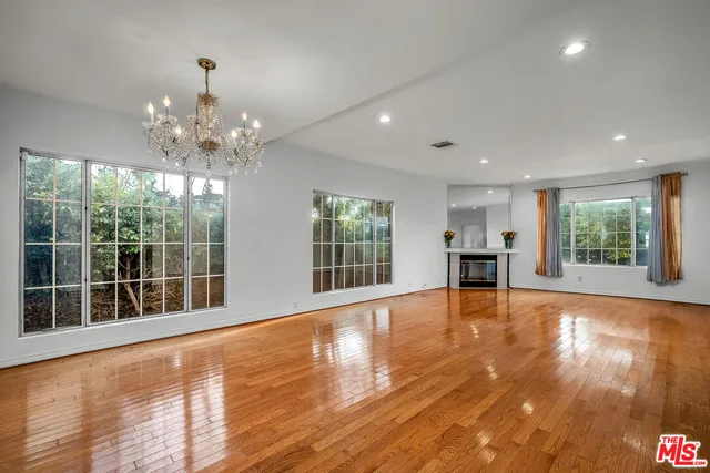 a view of an empty room with a fireplace and a window