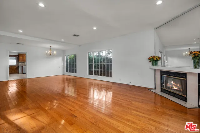 a view of empty room with wooden floor and fireplace