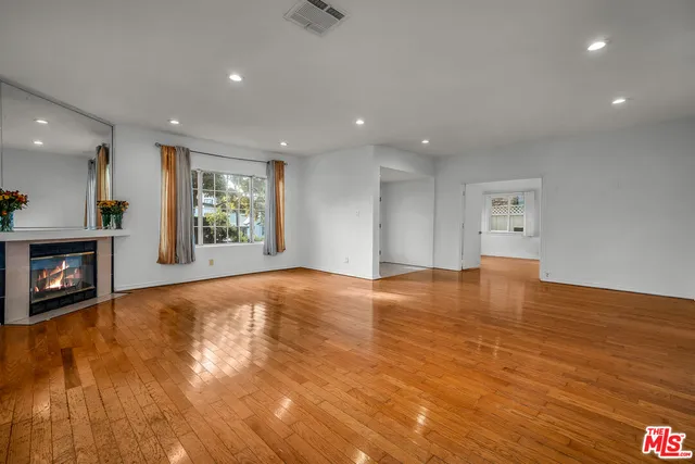 a view of an empty room with a fireplace and a window