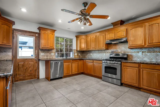 a kitchen with granite countertop a stove sink and cabinets