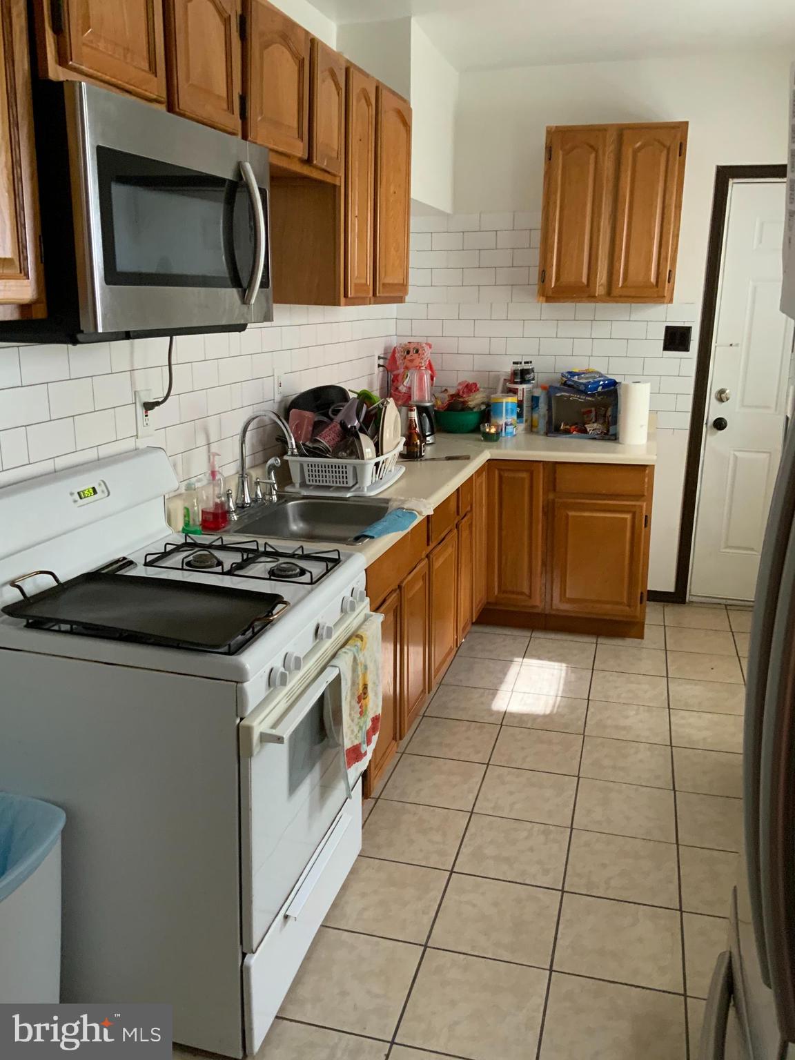 434 Birch Street Reading, PA 19604 - Photo 3 of 12 a kitchen with stainless steel appliances a sink a stove a microwave a sink and cabinets