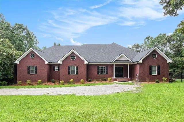 a front view of a house with a garden and yard