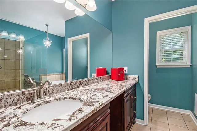 a en suite bathroom with a granite countertop sink and a mirror