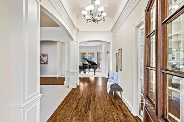 a view of a dining room and livingroom with furniture wooden floor a chandelier