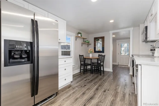 a kitchen with stainless steel appliances a refrigerator and wooden floor