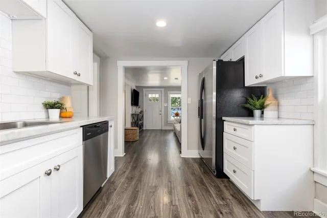 a kitchen with white cabinets and stainless steel appliances