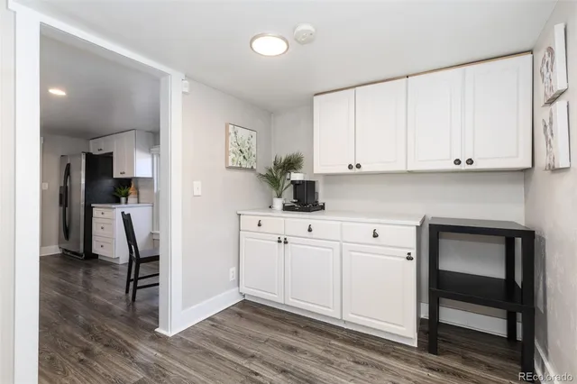 a kitchen with stainless steel appliances white cabinets and wooden floors