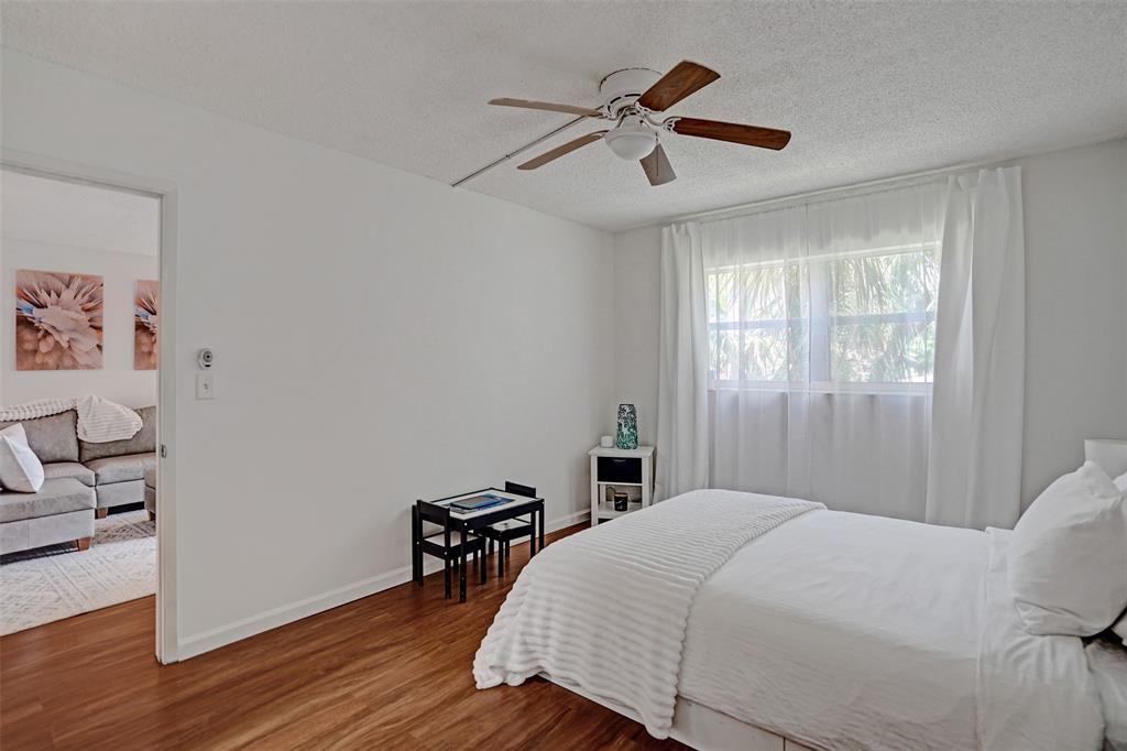 2350 Northeast 14th Street Causeway, Unit 203 Pompano Beach, FL 33062 - Photo 12 of 23 a bedroom with a bed and a chandelier