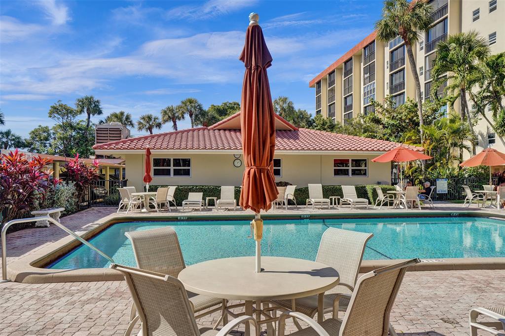 2350 Northeast 14th Street Causeway, Unit 203 Pompano Beach, FL 33062 - Photo 19 of 23 a patio with a table and chairs and potted plants